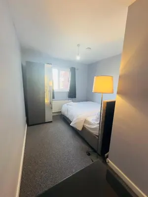 a small bedroom with a bed and a lamp at Cosy and Bright Stay Ipswich in Ipswich