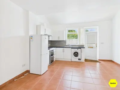 a kitchen with white appliances and a tile floor at New Spacious apartment in Milton