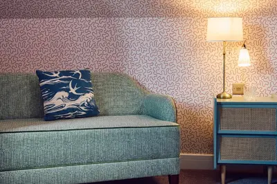 a living room with a couch with a pillow on it at The White Hart Inn in West Mersea