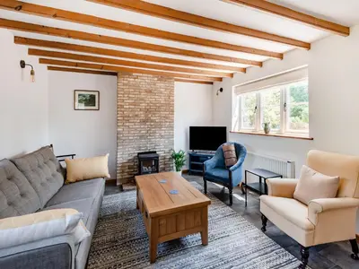 a living room with a couch and a table at The Pink Cottage