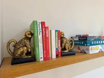 two books sitting on a shelf with books at 2 bed Elegant Flat in Stansted with parking in Stansted Mountfitchet