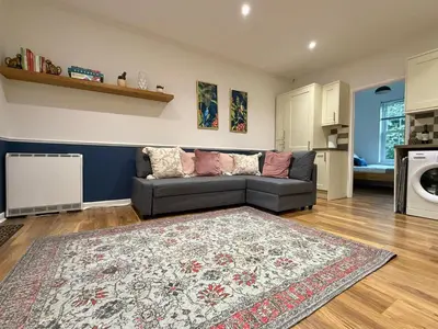 a living room with a couch and a rug at 2 bed Elegant Flat in Stansted with parking in Stansted Mountfitchet