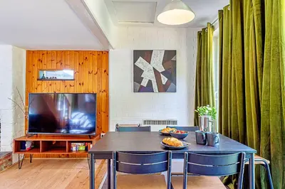 a dining room with a table and a television at Finest Retreats - Hollybush Studio in Knebworth