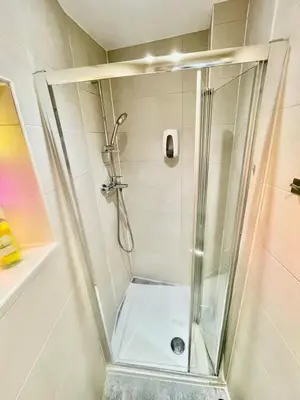 a shower with a glass door in a bathroom at Beautiful city centre studio - central location in Cambridge