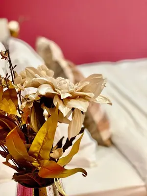 a vase filled with flowers sitting on a bed at Beautiful city centre studio - central location in Cambridge