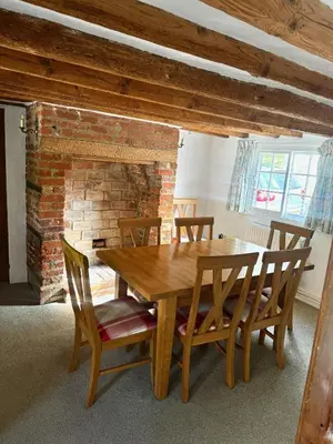 a wooden table and chairs in a room with a brick wall at Memorial University, Harlow Campus in Burnt Mill