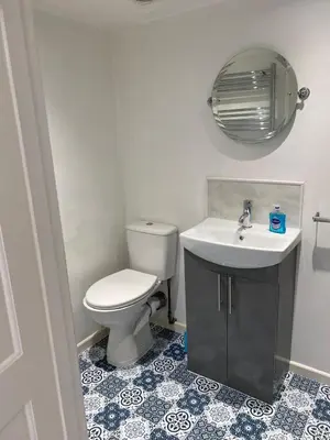 a bathroom with a toilet and a sink and a mirror at Oyster Lodge in West Mersea