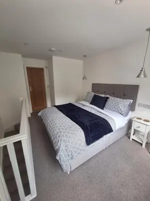 a bedroom with a large bed with a blue comforter at New Annexe in Gosfied in Gosfield
