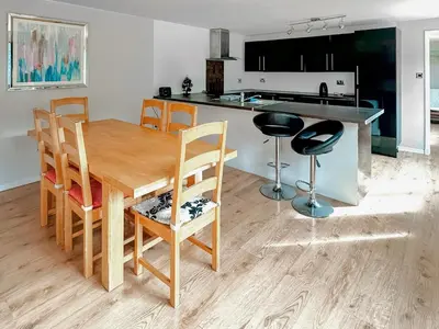 a kitchen and dining room with a wooden table and chairs at Spring Vale Bungalow in Colchester