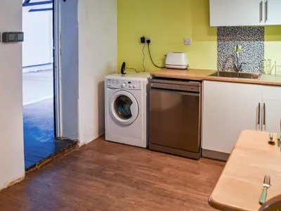a kitchen with a washing machine in a kitchen at The Pool House - Uk48229 in Tibenham