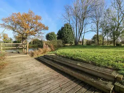a wooden path through a park with a field at Pond View Cottage - Uk48230 in Tibenham