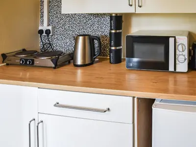 a kitchen counter with a microwave and a toaster oven at The Retreat - Uk48231 in Tibenham