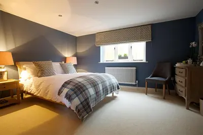 a bedroom with blue walls and a bed and a chair at The Packhorse Inn in Newmarket