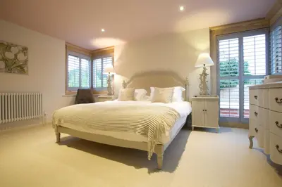 a bedroom with a large bed in a room with windows at The Packhorse Inn in Newmarket