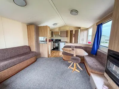 a living room with a couch and a table at Great 8 Berth Caravan With Unlimited Wi-Fi At Seawick Holiday Park, Ref 27213Sw in Clacton-on-Sea