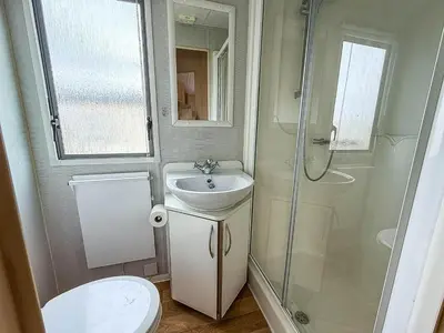 a bathroom with a toilet and a sink and a shower at Great 8 Berth Caravan With Unlimited Wi-Fi At Seawick Holiday Park, Ref 27213Sw in Clacton-on-Sea