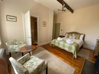 a bedroom with a bed and a table and chairs at The Old Vicarage BandB