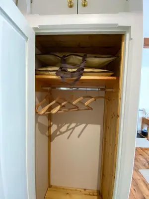 a closet in a house with wooden hangers at The Old Vicarage BandB
