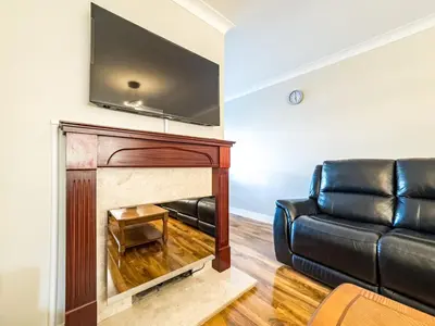 a living room with a couch and a fireplace at House - sleeps 7 private garden & parking in Basildon