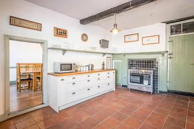 a kitchen with white cabinets and a microwave at Merchant Quarters, The Merchant House, Ipswich in Ipswich