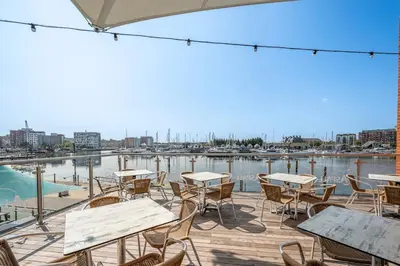 a patio with tables and chairs overlooking a marina at Merchant Quarters, The Merchant House, Ipswich in Ipswich