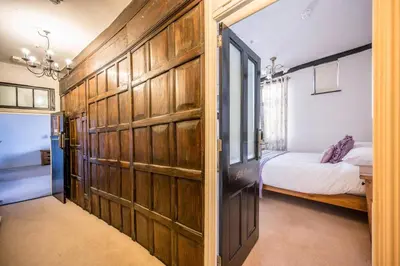 a bedroom with a wooden door with a bed in it at Silk Room, The Merchant House, Ipswich in Ipswich
