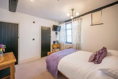 a bedroom with a bed and a television in it at Silk Room, The Merchant House, Ipswich in Ipswich