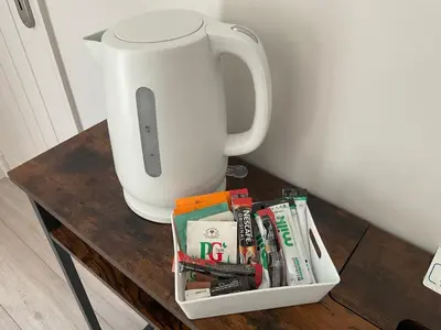 a table with a coffee pot and books on it at The Meadow Garden Guest Room in Newmarket