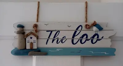 a sign hanging on a wall with a house at Beachside Terrace in Dovercourt