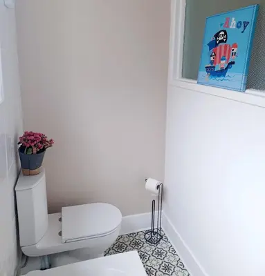 a bathroom with a toilet and a book on the wall at Beachside Terrace in Dovercourt