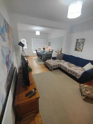 a living room with a blue couch and a table at Beachside Terrace in Dovercourt
