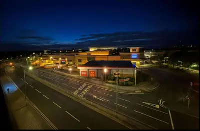 a city street with buildings and street lights at night at Modern 2 Bed Flat with parking Next to Basildon Station in Laindon
