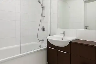 a white bathroom with a sink and a shower at Modern 2 Bed Flat with parking Next to Basildon Station in Laindon