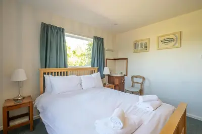 a bedroom with a large white bed and a window at 18 Linden Road - sleeps 5 - Less than a mile from the Aldeburgh Beach and a Vibrant High Street in Aldeburgh