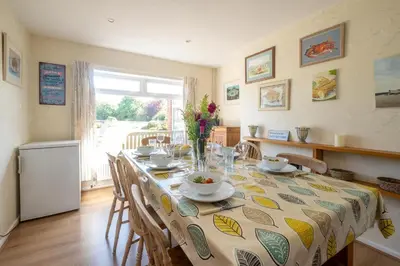 a dining room with a table and chairs and a window at 18 Linden Road - sleeps 5 - Less than a mile from the Aldeburgh Beach and a Vibrant High Street in Aldeburgh