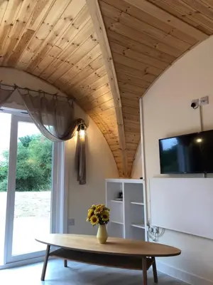 a living room with a table and a tv at Muntjac Cabin in Elmswell