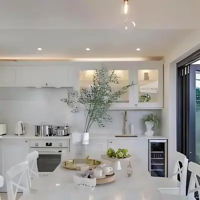a white kitchen with a table and chairs at Stunning house in the heart of Leigh-On-Sea in Leigh-on-Sea