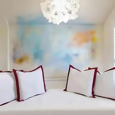 a bed with four pillows and a chandelier at Stunning house in the heart of Leigh-On-Sea in Leigh-on-Sea