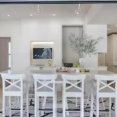 a kitchen with a white table and white stools at Stunning house in the heart of Leigh-On-Sea in Leigh-on-Sea