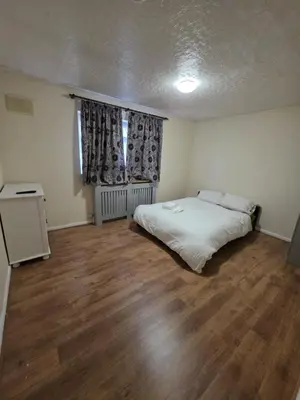 a bedroom with a bed and a wooden floor at Spacious Double Room in Basildon Essex in Basildon