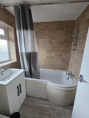 a bathroom with a bath tub and a sink at Spacious Double Room in Basildon Essex in Basildon