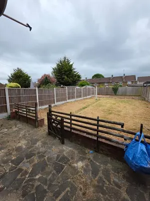 a wooden bench with a blue bag next to a fence at Spacious Double Room in Basildon Essex in Basildon