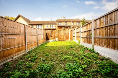 a backyard with a fence and a green yard at Stunning 7-Bed, 6-Bath Home in Essex with Free Parking in Clacton-on-Sea