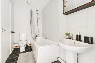 a white bathroom with a sink and a toilet at Stunning 7-Bed, 6-Bath Home in Essex with Free Parking in Clacton-on-Sea