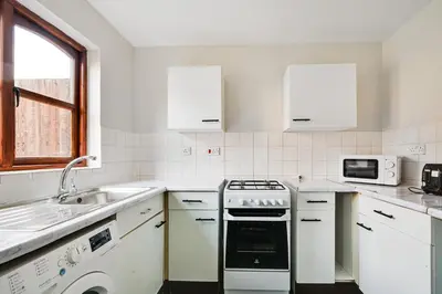 a white kitchen with a sink and a stove at Stunning 7-Bed, 6-Bath Home in Essex with Free Parking in Clacton-on-Sea
