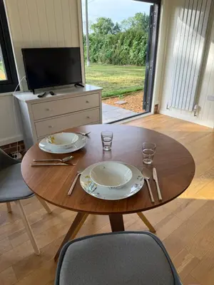 a wooden table with two plates and glasses on it at The Den in Scoulton