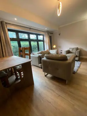 a living room with a couch and a table at Two double bedroom self contained Retreat in Thundersley
