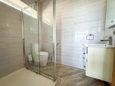 a bathroom with a toilet and a glass shower at Oceanfront 4BR Beach Retreat in Holland-on-Sea