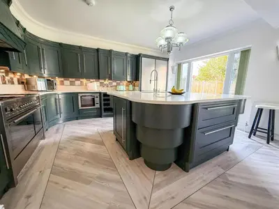 a large kitchen with green cabinets and a large island at Oceanfront 4BR Beach Retreat in Holland-on-Sea