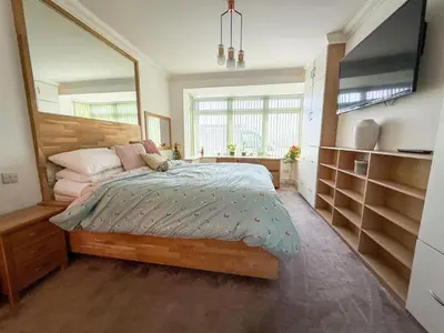 a bedroom with a bed and a large mirror at Oceanfront 4BR Beach Retreat in Holland-on-Sea